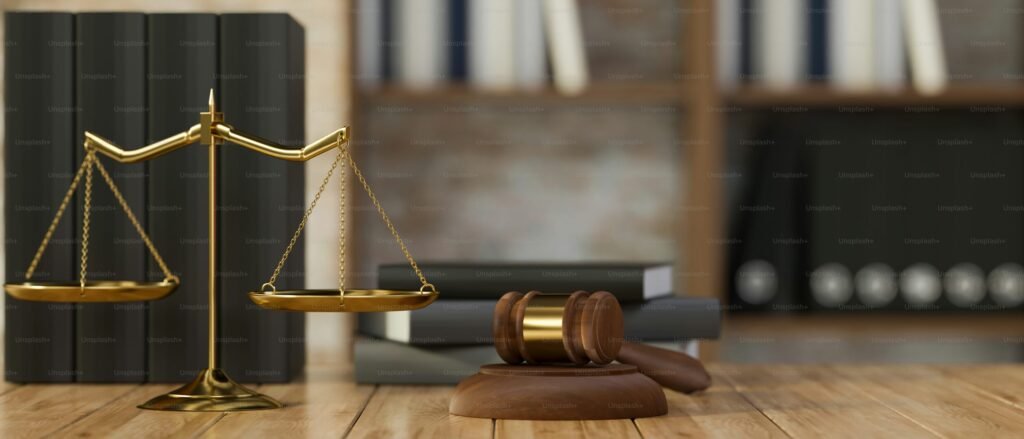 Golden scales of justice and a wooden gavel placed on a desk in front of law books, symbolizing court records, legal proceedings, and online legal content visibility.